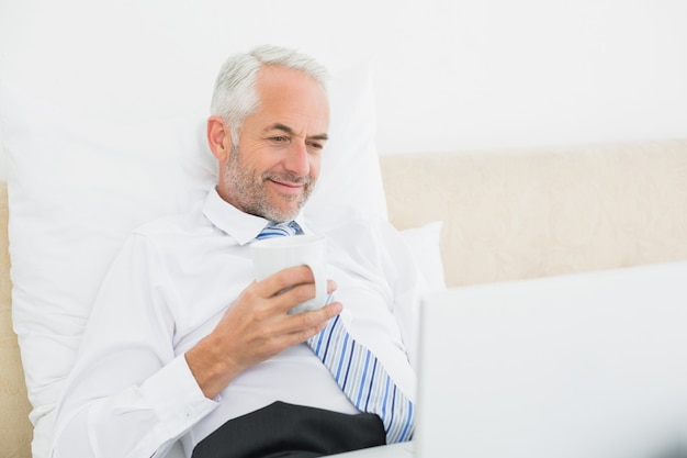 Sorrindo, maduras, homem negócios, usando computador portátil, cama