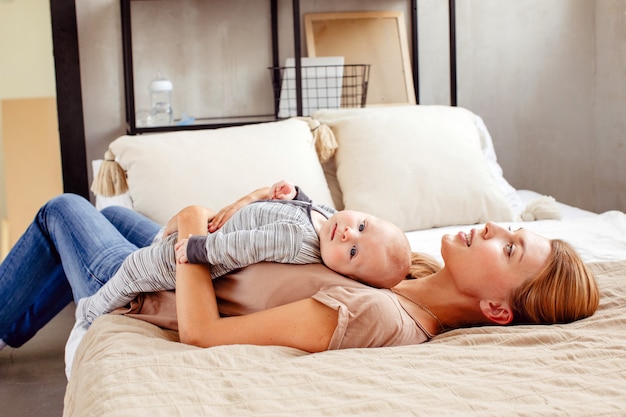 Sorrindo, mãe, com, bebê, encontrar-se cama