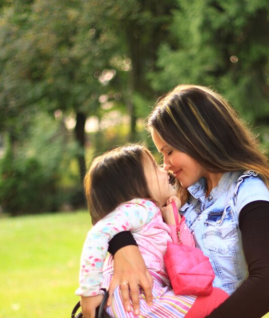 Sorrindo, mãe e filha na natureza. pessoas felizes ao ar livre