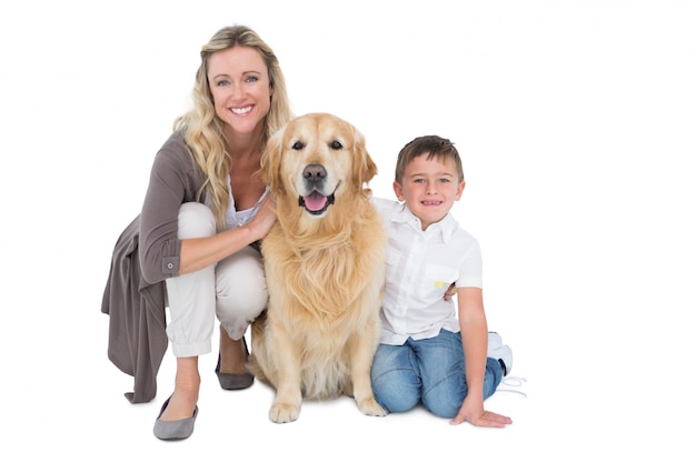 Sorrindo mãe e filho acariciando seu golden retriever