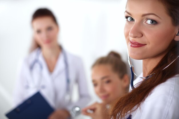 Sorrindo médica com uma pasta em uniforme permanente no hospital