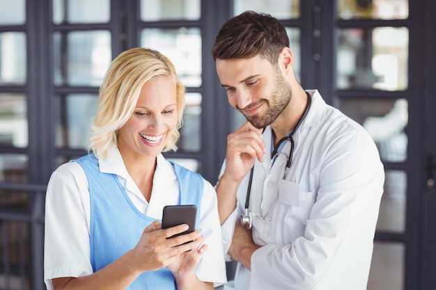 Sorrindo médicos usando telefone celular