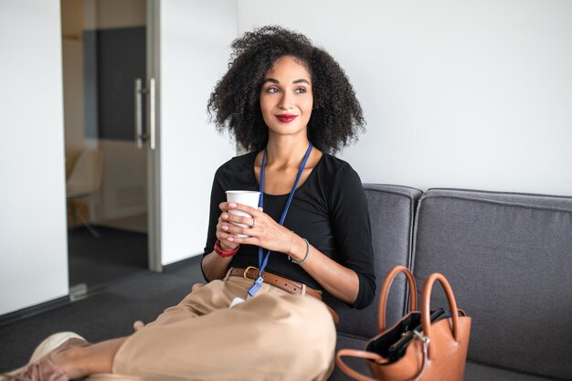 Sorrindo muito morena mulher com uma xícara de café