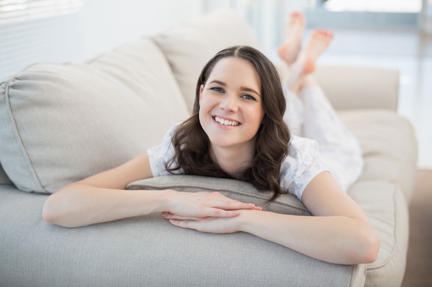 Foto sorrindo mulher bonita deitada em um sofá aconchegante