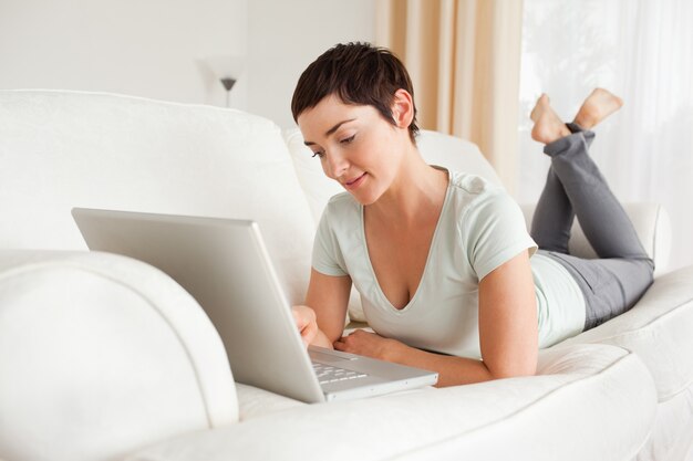 Sorrindo, mulher de cabelos curtos, usando um laptop