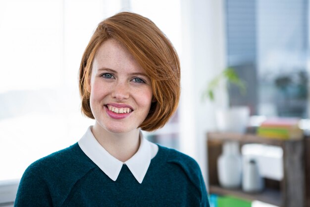 Sorrindo mulher de negócios hipster, de pé em seu escritório