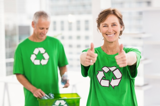 Sorrindo mulher eco-minded fazendo polegares para cima