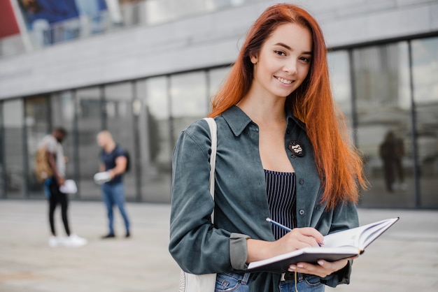 Sorrindo mulher elegante com caderno