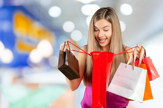 Sorrindo, mulher jovem, com, bolsas para compras, sobre, centro comercial