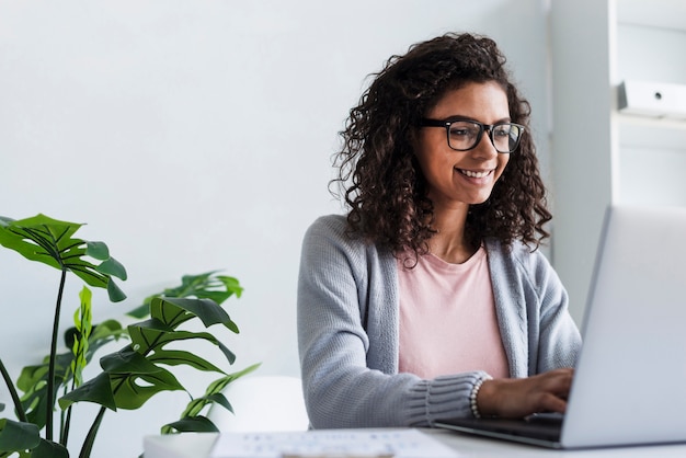 Foto sorrindo, mulher jovem, trabalhando, em, laptop, em, escritório