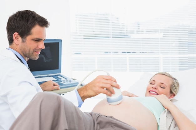 Sorrindo mulher loira grávida com uma ultra-sonografia