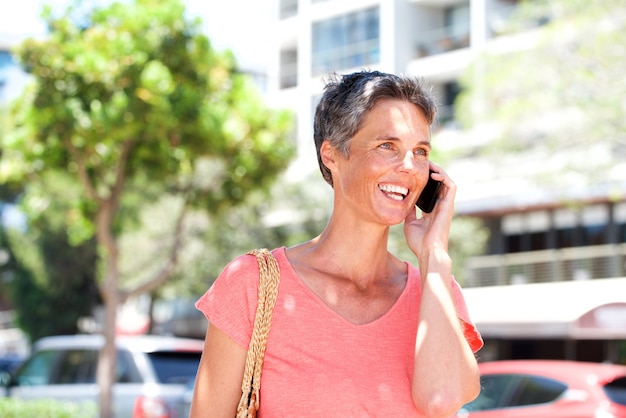 Sorrindo, mulher madura, falando, ligado, cellphone, ao ar livre