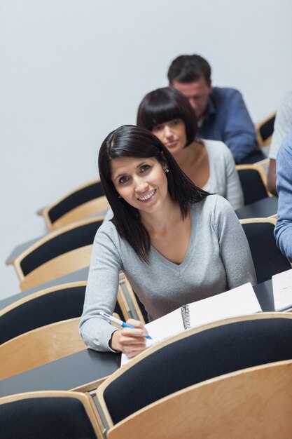 Foto sorrindo mulher olhando para cima da tomada de notas