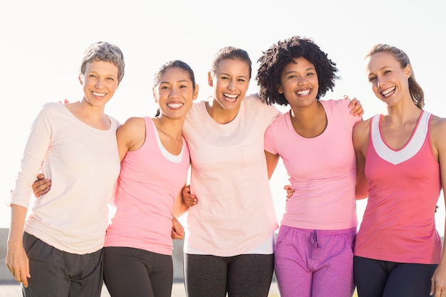 Sorrindo mulheres com rosa para câncer de mama