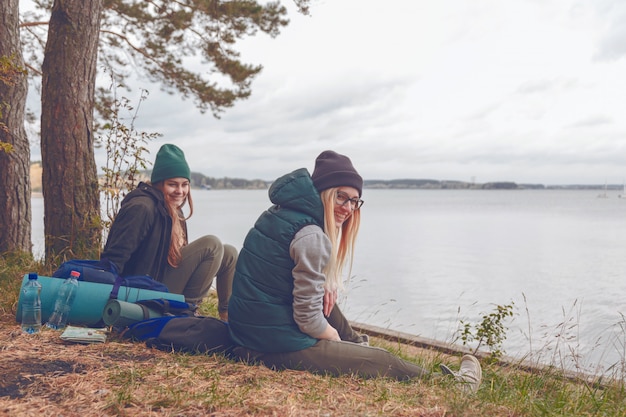 Foto sorrindo, mulheres jovens, descansar, durante, viajando, perto, a, lago