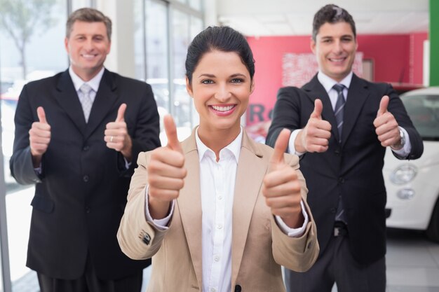 Sorrindo, negócio, equipe, ficar, enquanto, dar, polegares cima, em, novo, carro, showroom