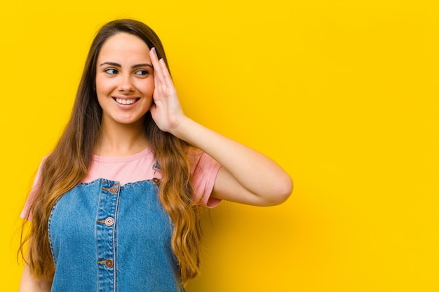 Sorrindo, olhando curiosamente para o lado, tentando ouvir fofocas ou ouvir um segredo