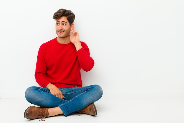 sorrindo, olhando curiosamente para o lado, tentando ouvir fofocas ou ouvir um segredo