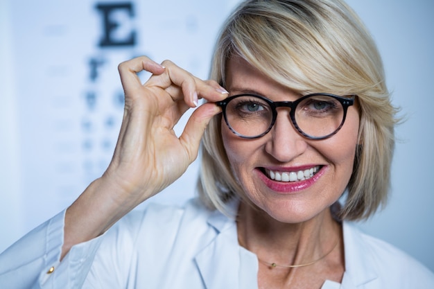 Sorrindo optometrista feminino usando óculos