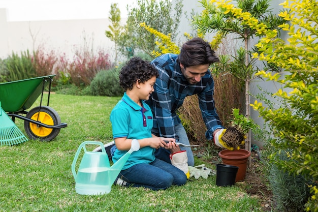 Sorrindo pai e filho jardinando