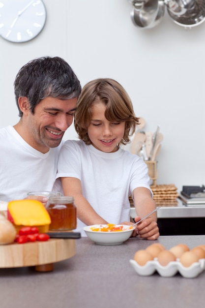 Sorrindo pai e filho tomando café da manhã juntos