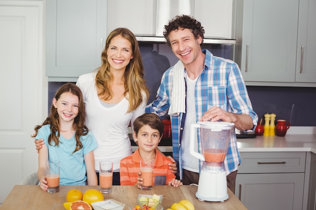 Sorrindo, pais e filhos com suco de frutas