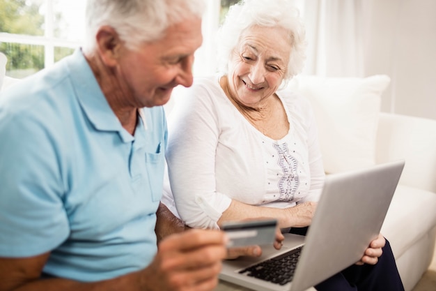 Sorrindo, par velho, usando computador portátil, casa