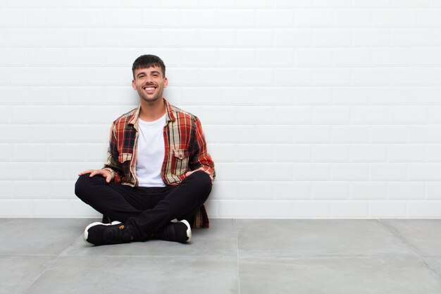 sorrindo para a câmera com os braços cruzados e uma expressão feliz, confiante e satisfeita, vista lateral