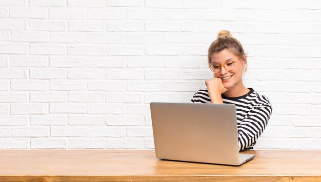 Sorrindo para a câmera com os braços cruzados e uma expressão feliz, confiante e satisfeita, vista lateral