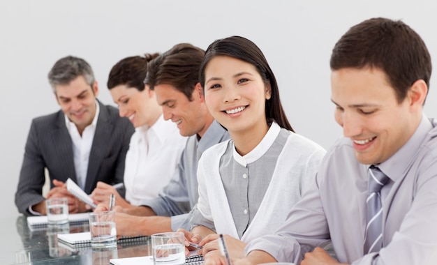 Sorrindo parceiros de negócios tomando notas em uma reunião