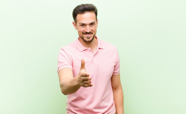 Sorrindo, parecendo feliz, confiante e amigável, oferecendo um aperto de mão para fechar um acordo, cooperando