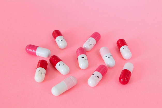 Sorrindo pílulas no fundo rosa