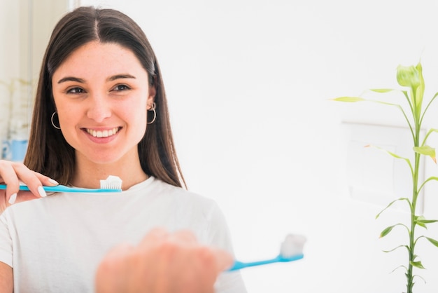 Foto sorrindo, retrato, de, um, mulher jovem, em, espelho, segurando, escova de dentes, em, mão