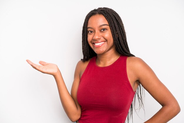 sorrindo, sentindo-se confiante, bem-sucedida e feliz, mostrando o conceito ou a idéia no espaço da cópia ao lado