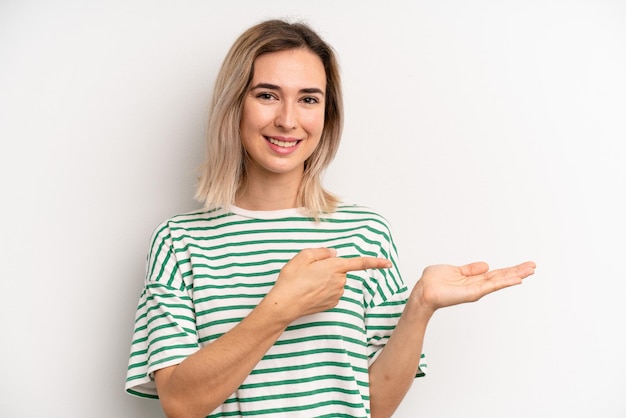 Sorrindo, sentindo-se feliz, despreocupado e satisfeito, apontando para o conceito ou ideia no espaço da cópia ao lado