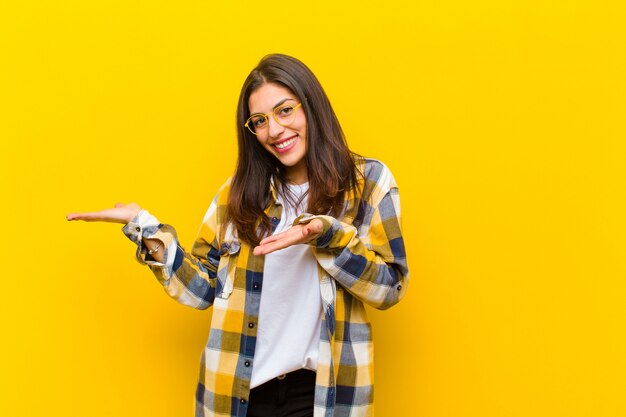 sorrindo, sentindo-se feliz, despreocupado e satisfeito, apontando para o conceito ou idéia no espaço da cópia ao lado