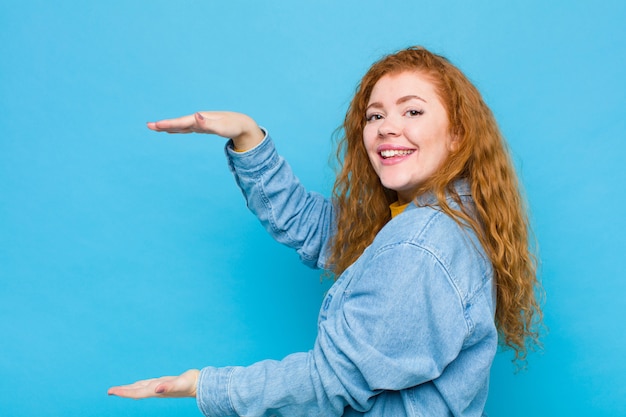 sorrindo, sentindo-se feliz, positivo e satisfeito, segurando ou mostrando o objeto