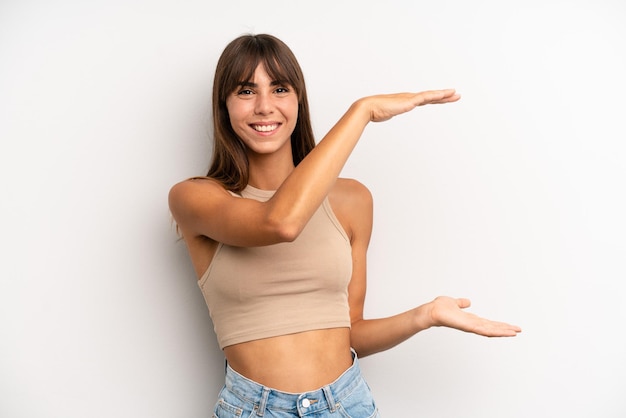 Sorrindo, sentindo-se feliz, positivo e satisfeito, segurando ou mostrando objeto ou conceito no espaço da cópia