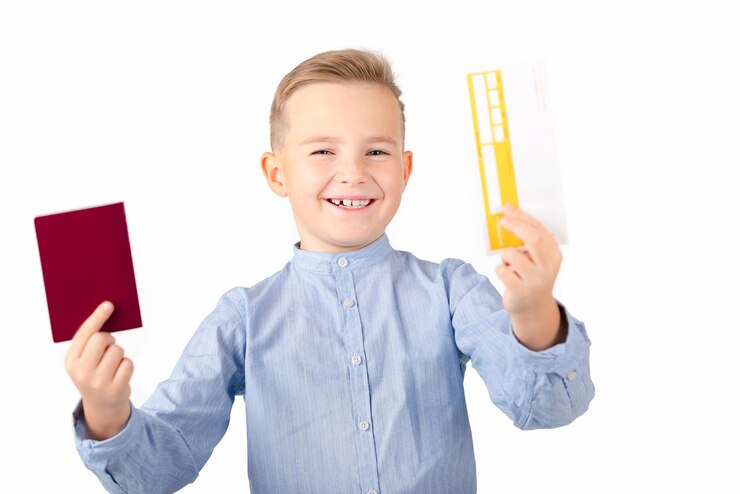Foto sorrindo surpreendido menino europeu com camisa azul segurar bilhete e passaporte isolado em fundo branco fechar
