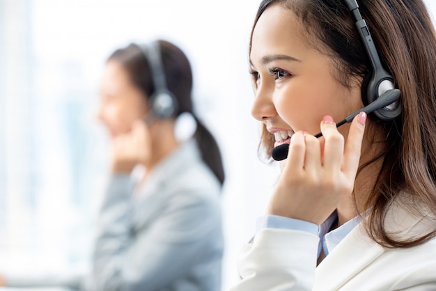 Sorrindo telemarketing mulher asiática trabalhando no escritório do centro de chamada