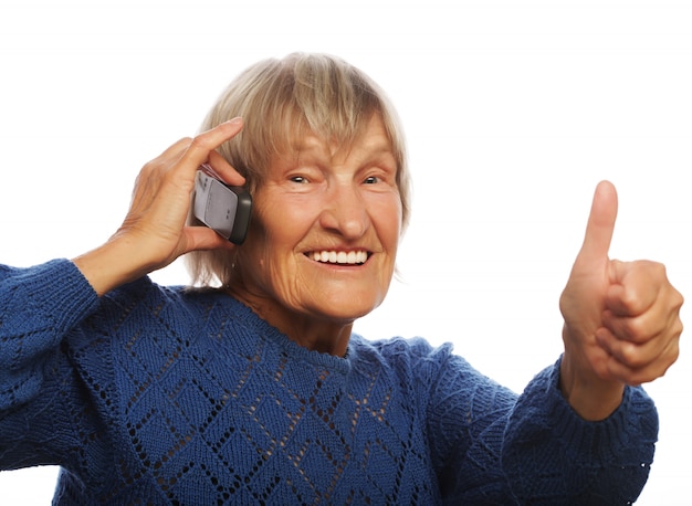 Sorrindo velha se comunicando através do telefone móvel