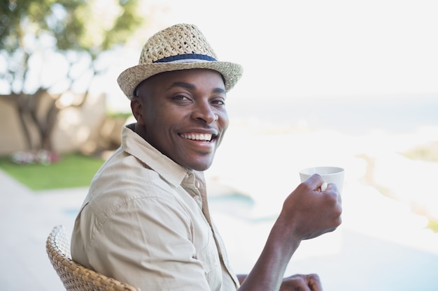 Sorrir homem relaxando em seu jardim tomando café