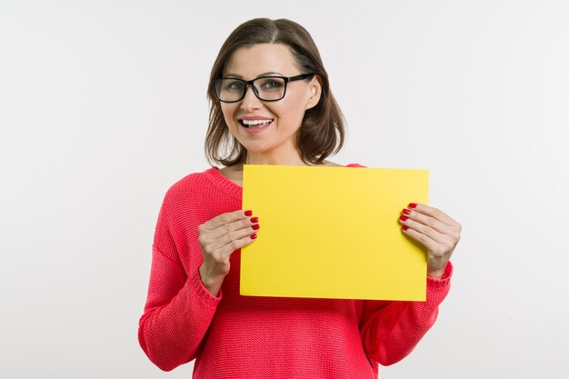 Sorrir meio envelhecido mulher com folha de papel amarela