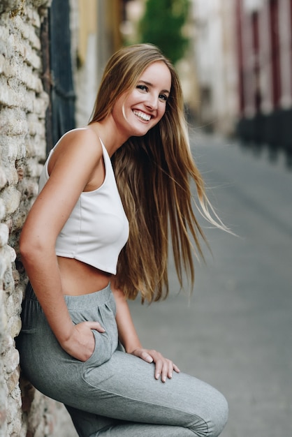 Sorrir menina loira com cabelo liso em fundo urbano
