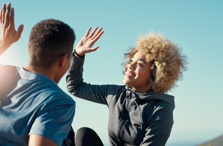 Foto sorriso alto cinco e apoio com casal e treinamento de fitness para exercícios de saúde e objetivos ao ar livre vencedor de sucesso e parceria com homem e mulher para exercício bem-estar e descanso esportivo