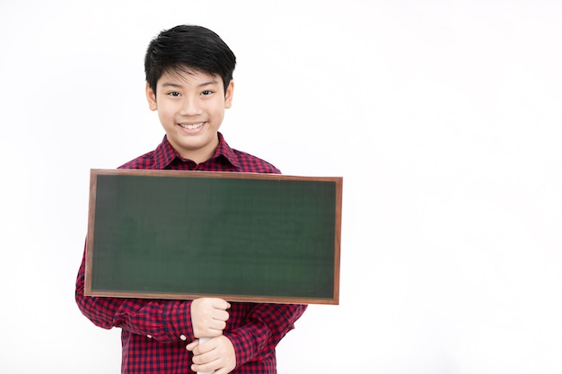 Sorriso asiático e mão do menino que guardam a placa vazia verde.