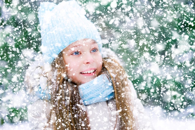 Sorriso brilhante de uma menina bonitinha e neve caindo