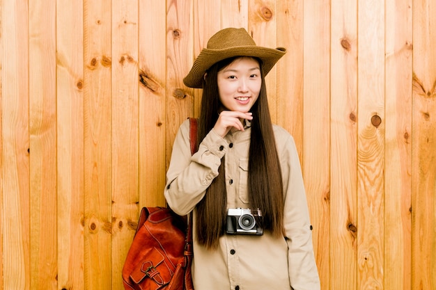 Sorriso chinês novo da mulher do viajante queixo feliz e seguro, tocante com mão.