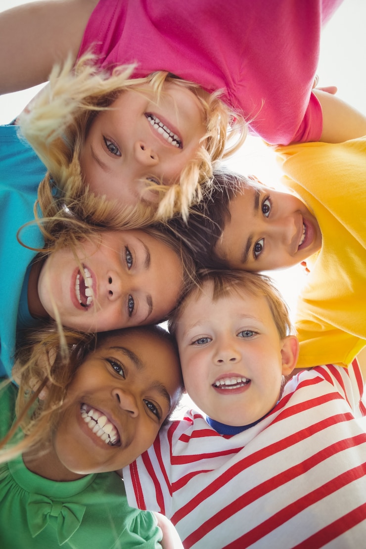 Foto sorriso colegas de classe com os braços em volta olhando para a câmera