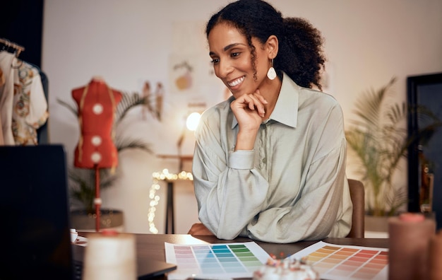 Sorriso de comércio eletrônico e designer de moda negra em estúdio criativo para fabricação de roupas e venda on-line design de tecido e proprietária de inicialização de mulher feliz com vendas pela internet na mesa de escritório em casa